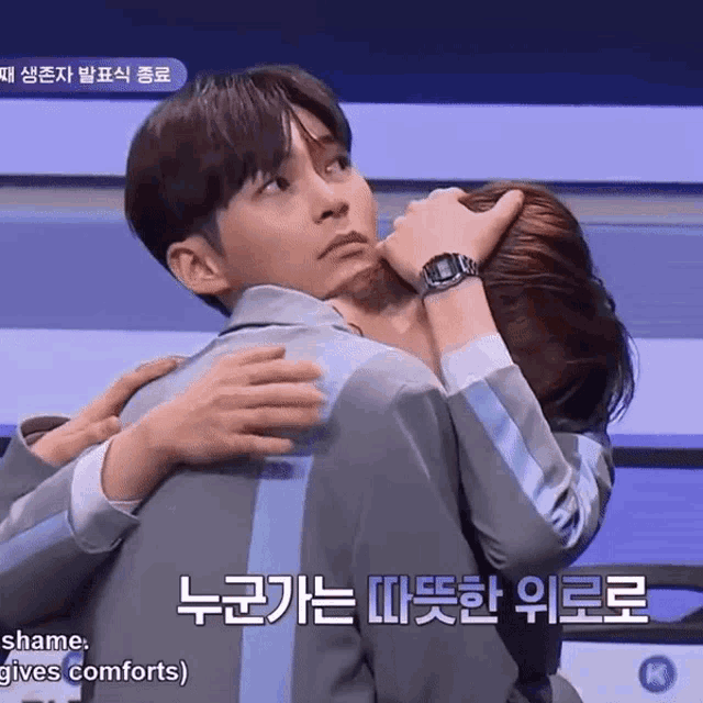 a man wearing a watch is hugging another man with korean writing on the bottom