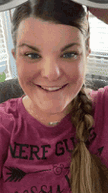 a woman wearing a purple shirt that says were guys is smiling
