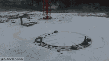 a black and white photo of a manhole cover open on a concrete surface .
