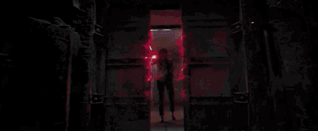 a person is standing in front of a fire in the dark