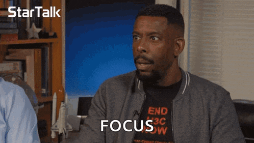 a man wearing a t-shirt that says " end racism " is talking to another man