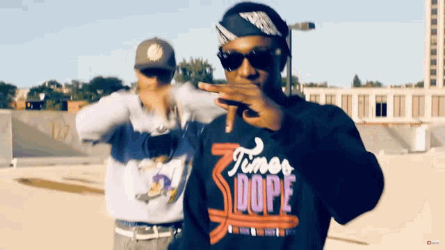 a man wearing a shirt that says timer dope is standing next to another man