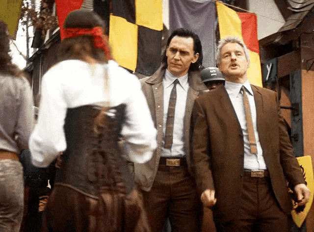 two men in suits are standing next to each other in front of a crowd .