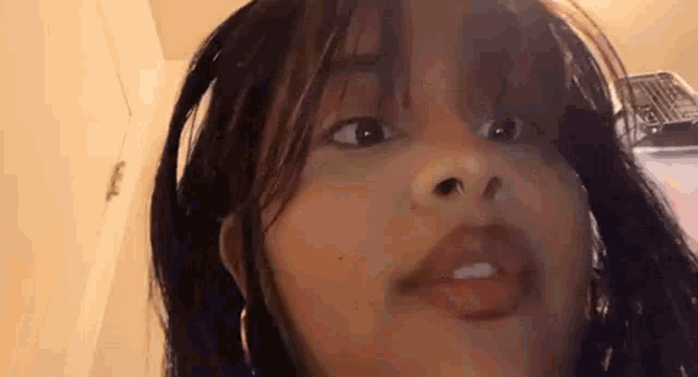 a close up of a young girl making a funny face with her mouth open .