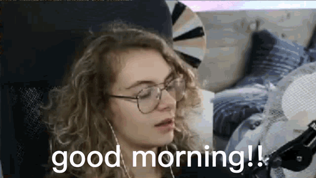 a woman wearing glasses and headphones is sitting in a chair and saying good morning .