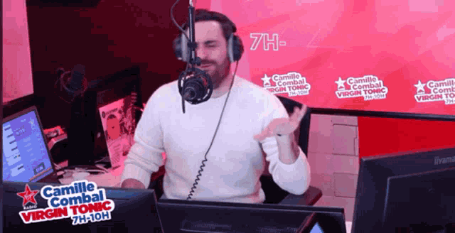 a man wearing headphones is talking into a microphone for camille combat virgin tonic