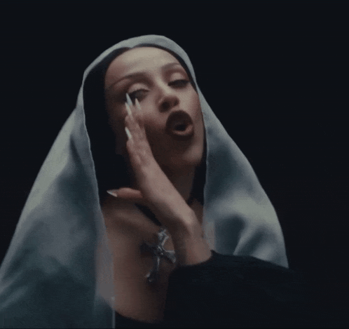 a woman with long nails and a white veil on her head