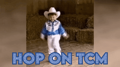 a little boy in a cowboy outfit is dancing in front of hay bales