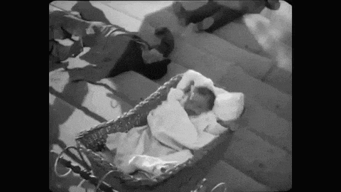 a black and white photo of a baby in a carriage