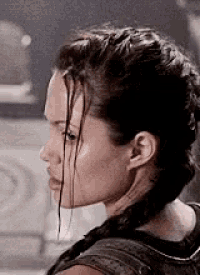 a close up of a woman 's face with a braided hairstyle .