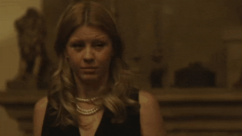 a woman is holding a gun in her hand and shooting it in a room .