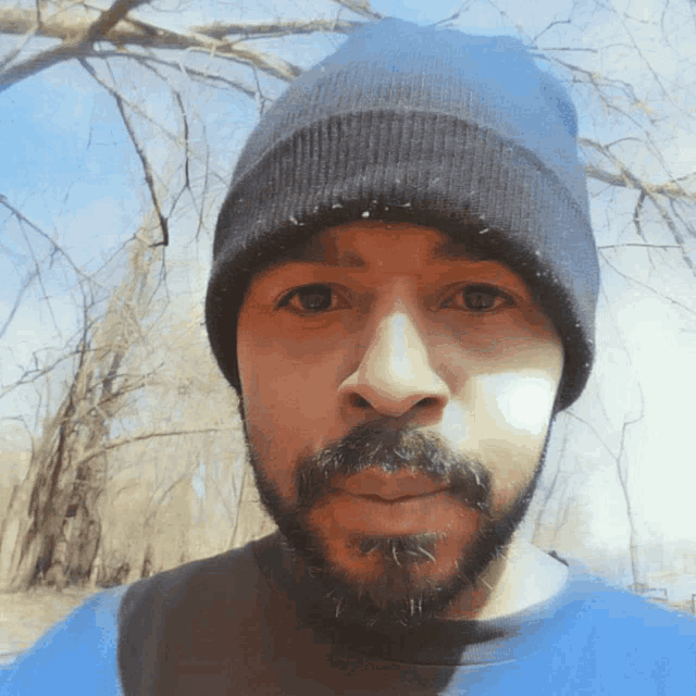 a man with a beard wears a black beanie