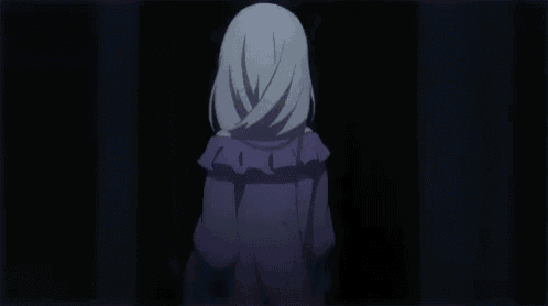 a white haired anime girl in a purple dress is standing in a dark room with her hand up .