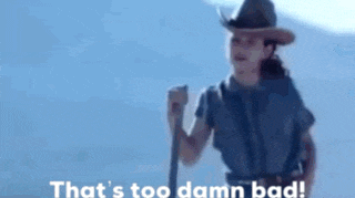 a woman in a cowboy hat is holding a stick and says that 's too damn bad .