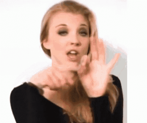 a woman is making a funny face with her hands while wearing a black shirt .