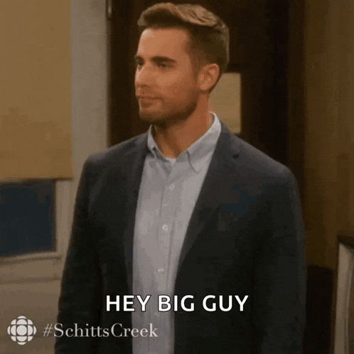 a man in a suit and blue shirt is saying hey big guy .