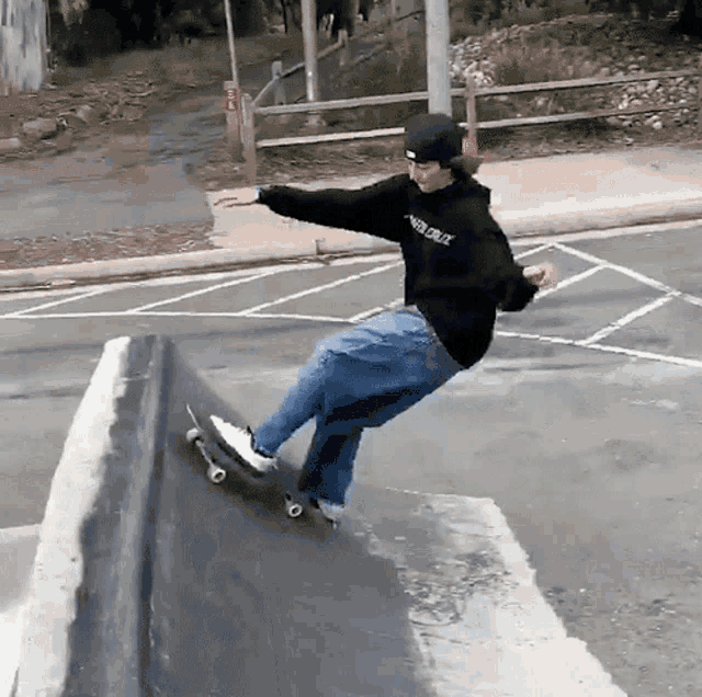 a person wearing a santa cruz hoodie is riding a skateboard down a ramp