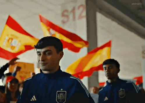 a man in an adidas jacket stands in front of a crowd