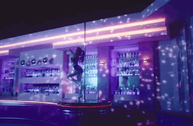 a woman dancing on a pole in a bar