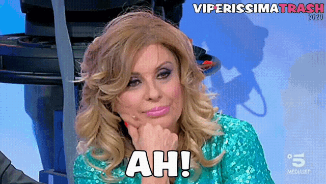 a woman in a green sequined top says " ah "