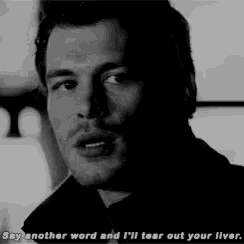 a black and white photo of a man with the words `` say another word and i 'll tear out your liver . ''