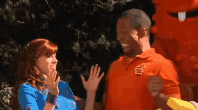 a man in an orange shirt with the letter t on it