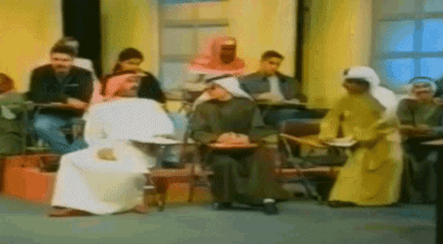 a blurred image of a group of people sitting in a room
