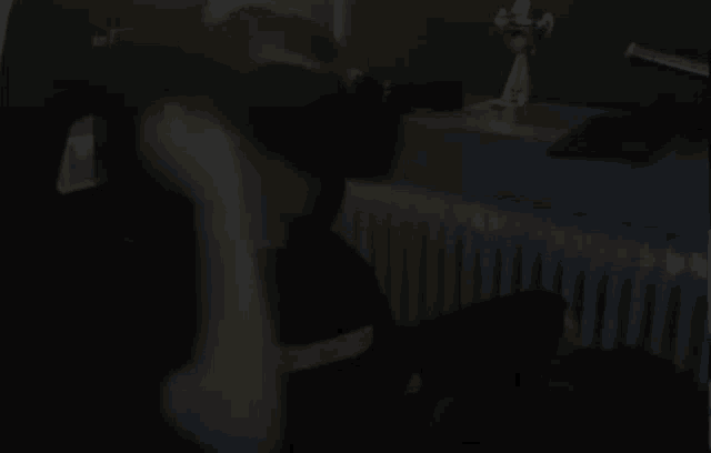 a person is sitting in a dark room with a radiator