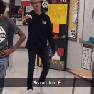 a man in a black shirt is dancing in a hallway with the words please stop in the corner