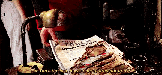 a person is holding a newspaper that says the torch torched how s that for dramatic irony