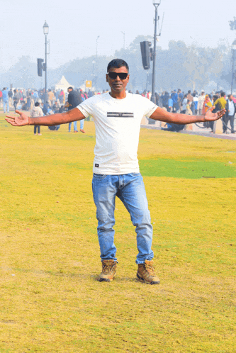 a man with his arms outstretched wearing a white t-shirt that says ' dc ' on the front