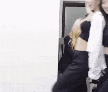 a woman in a white shirt is standing next to another woman in a black top