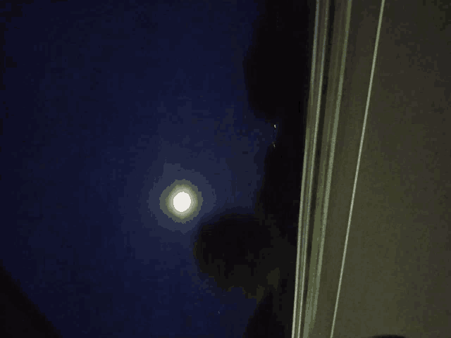 a full moon shines brightly in the night sky