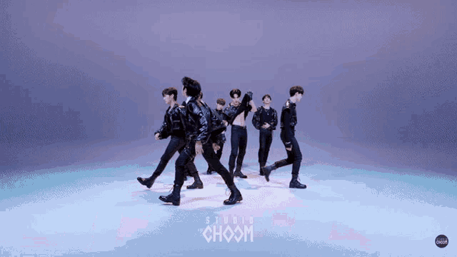 a group of men are dancing in front of a studio choom logo