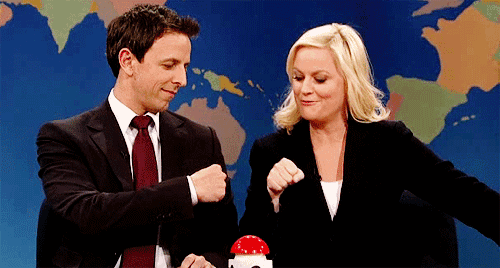 a man and a woman fist bump in front of a map