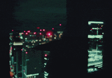 a person standing in front of a city at night