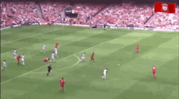 a blurry picture of a soccer game with a liverpool flag in the background .