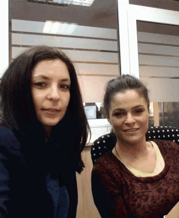 two women are posing for a picture in front of a glass door