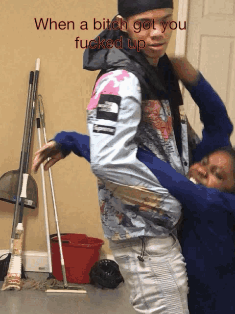 a man in a supreme jacket is carrying a woman in his arms