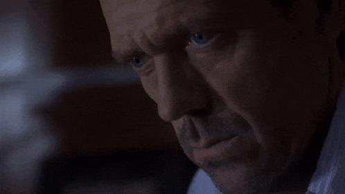 a close up of a man 's face with blue eyes in a dark room