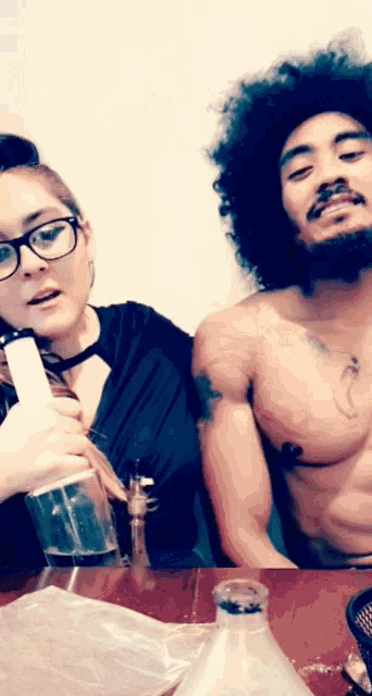 a man and a woman are smoking a bong together