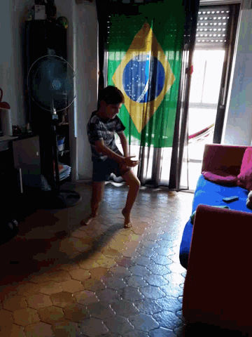 a boy is laying on the floor in front of a large brazilian flag