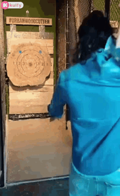 a person is throwing an axe at a target that says urbanwoodcutter on it