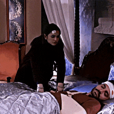 a woman standing next to a man in a hospital bed
