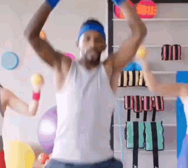 a man in a white tank top is jumping in the air