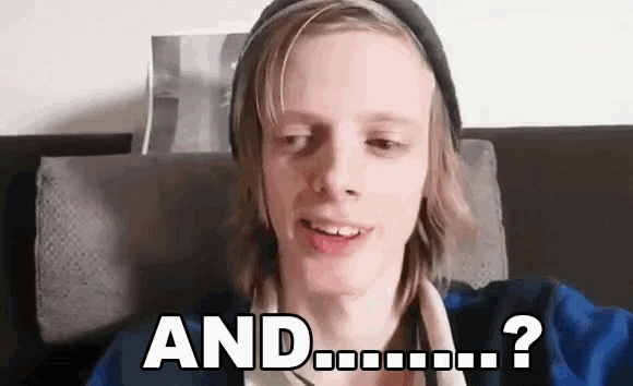 a young man wearing a hat and a blue jacket is sitting on a couch and says `` and ... ? '' .