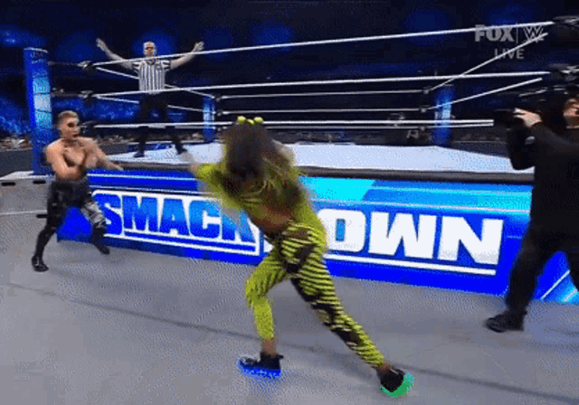 a woman in a green outfit is dancing on a smackdown ring