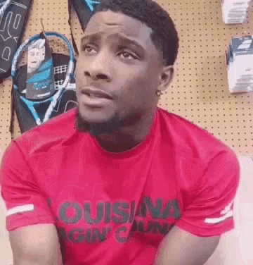 a man is wearing a red shirt that says louisiana gin ' cajun