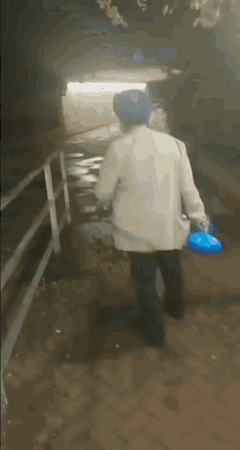 a man in a white shirt and blue hat is walking down a brick sidewalk