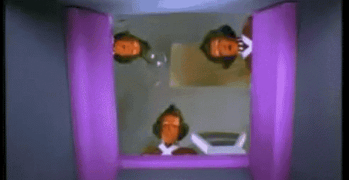 a group of people standing in a room with a purple door